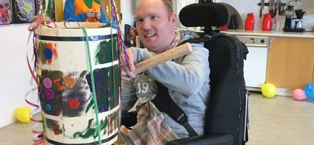 Mand i kørestol i gang med at slå katten af tønden