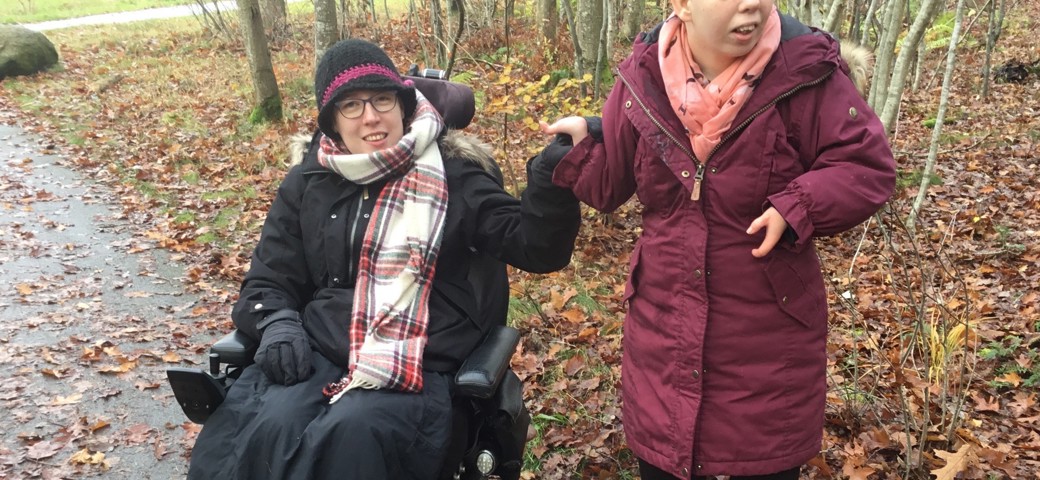 To personer i en skov inklusivt en i kørestol