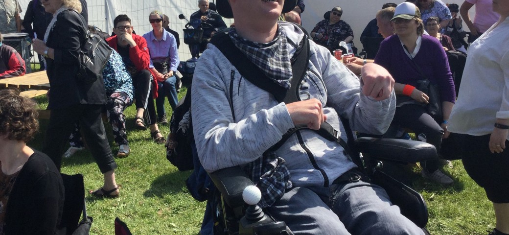 Mand i kørestol sidder og smiler i solskinsvejr på Skive Festival 2019